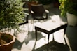 A classic outdoor side table beside a cozy patio chair, bathed in warm evening light.