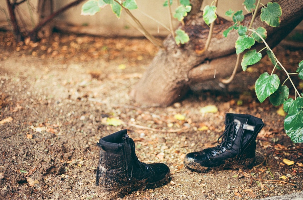 botas de couro preto no solo marrom