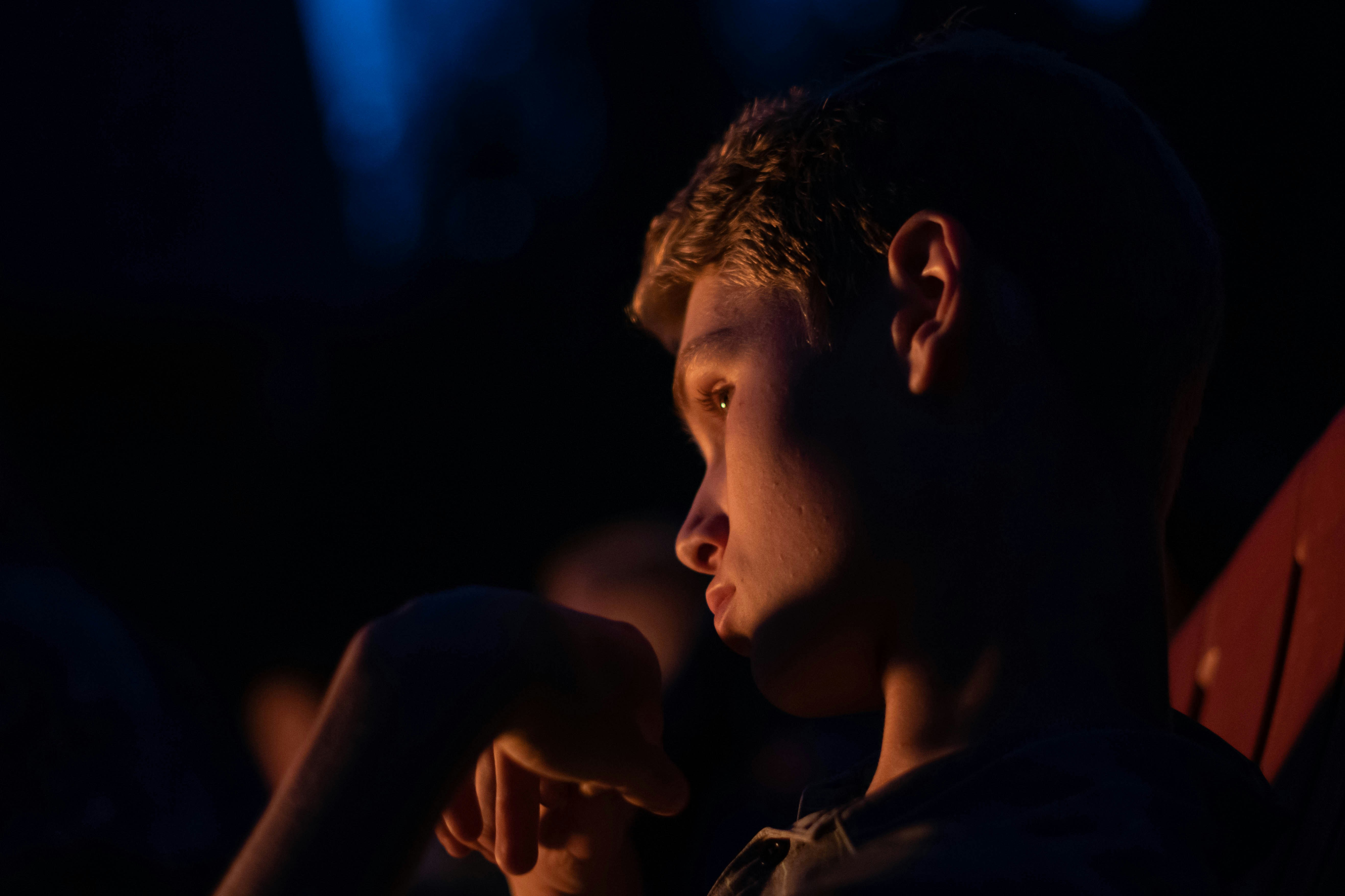 man in black shirt holding lighted cigarette stick