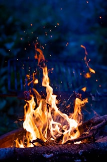 An animated scene of a lively fire sprite playfully weaving through pages of a manuscript under a starry sky.