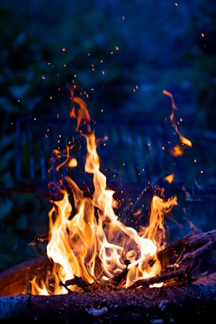 An animated scene of a lively fire sprite playfully weaving through pages of a manuscript under a starry sky.