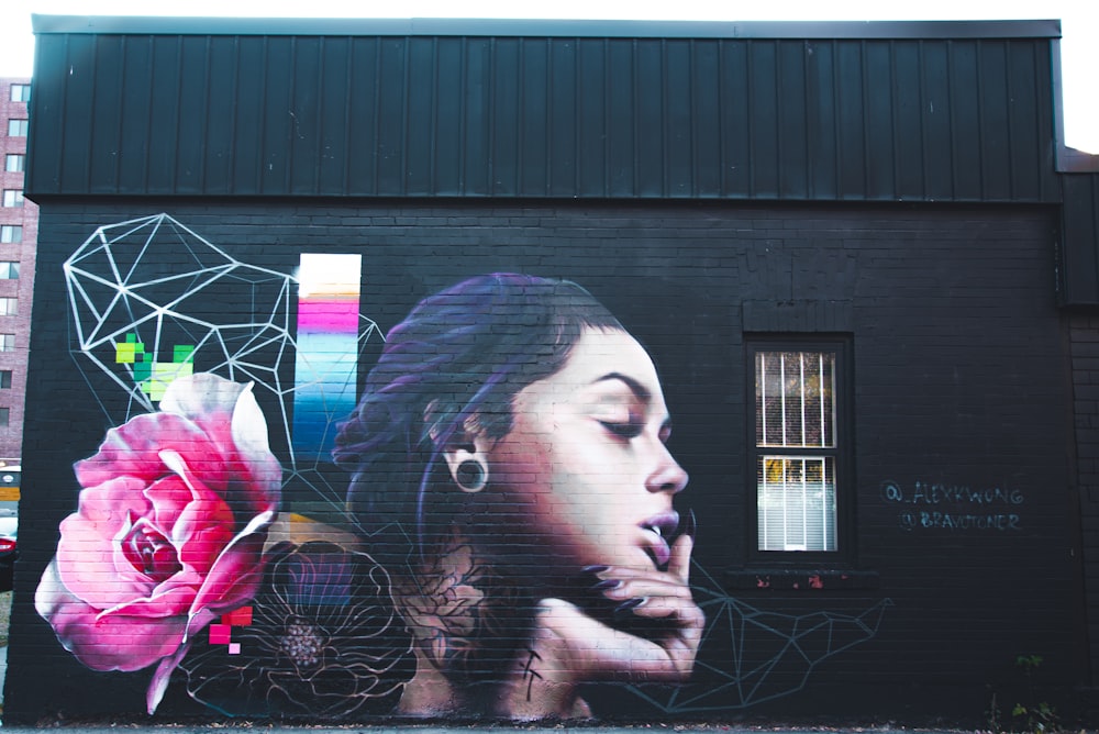 woman in black shirt holding pink flower