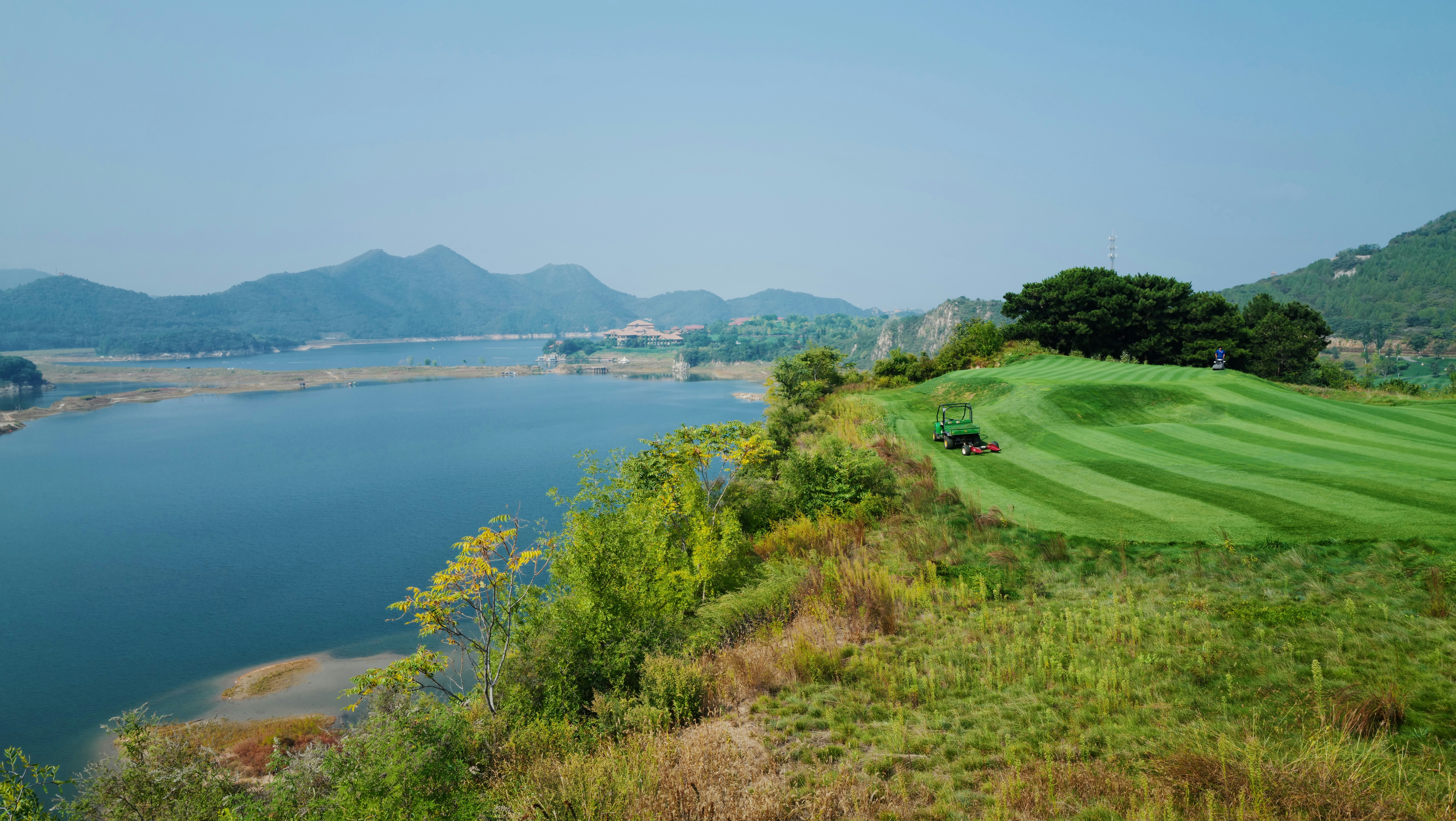 Wide shot of a pristine UK golf course fairway with defined mowing stripes