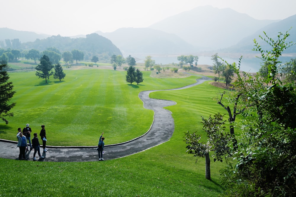 person in black jacket standing on green grass field during daytime