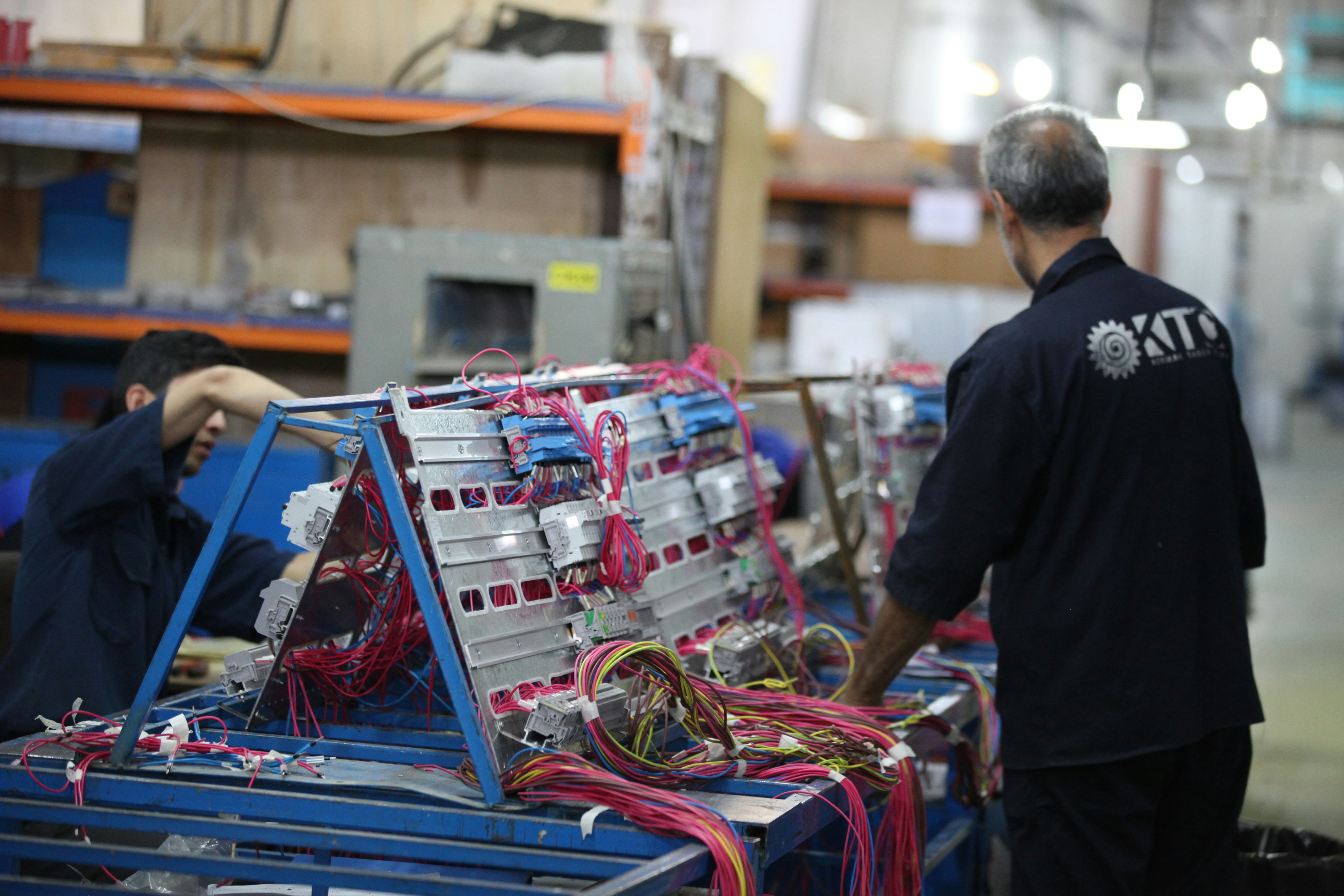 man in black shirt standing beside blue and red plastic crates