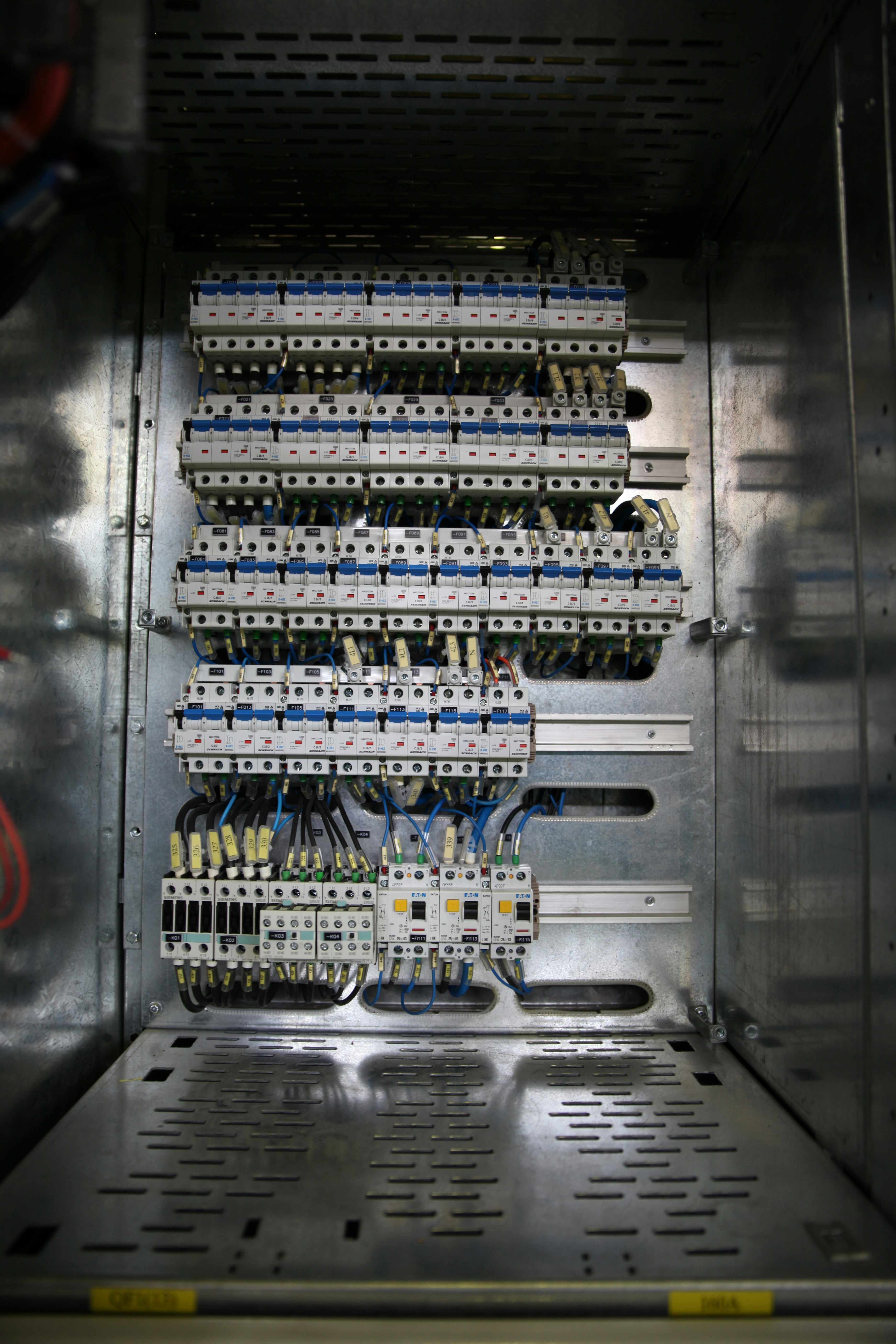 Close-up of circuit breaker panel in dim industrial environment, low-key moody lighting