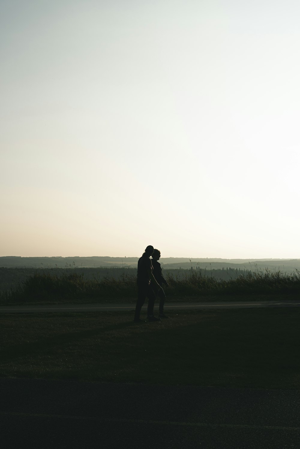 silhouette of man standing on grass field during daytime