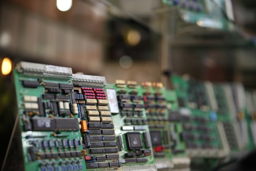 A close-up view of several circuit boards featuring numerous microchips and electronic components, arranged in a slightly tilted alignment with a shallow depth of field that results in a blurred background.