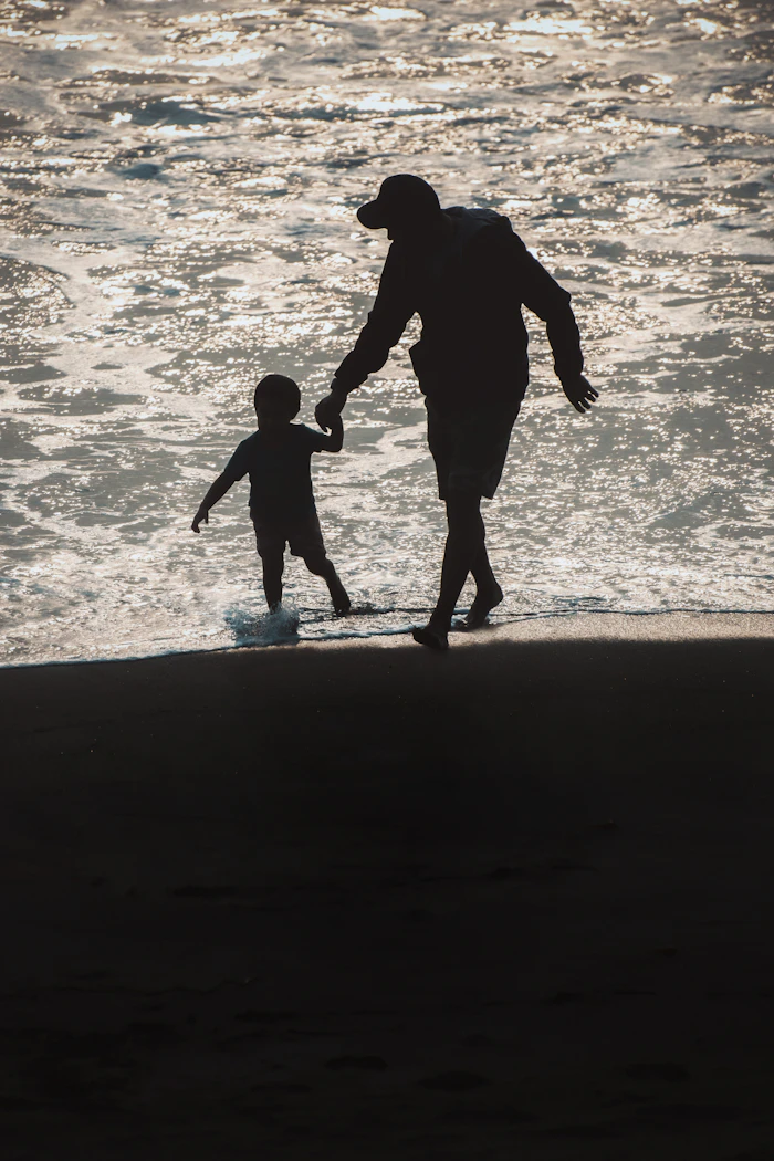 Parent and child walking on the beach