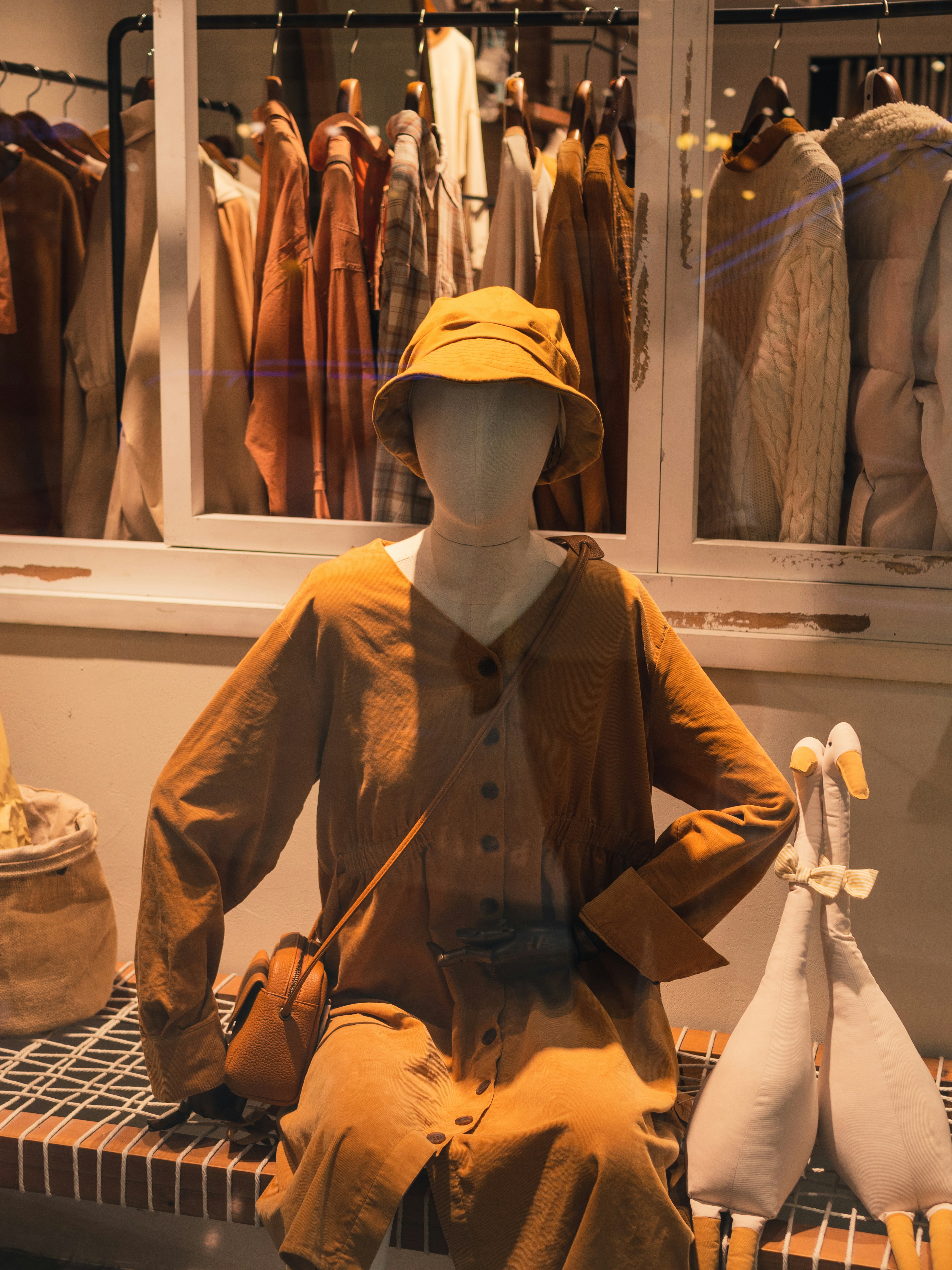 a mannequin sitting on a bench in front of a window