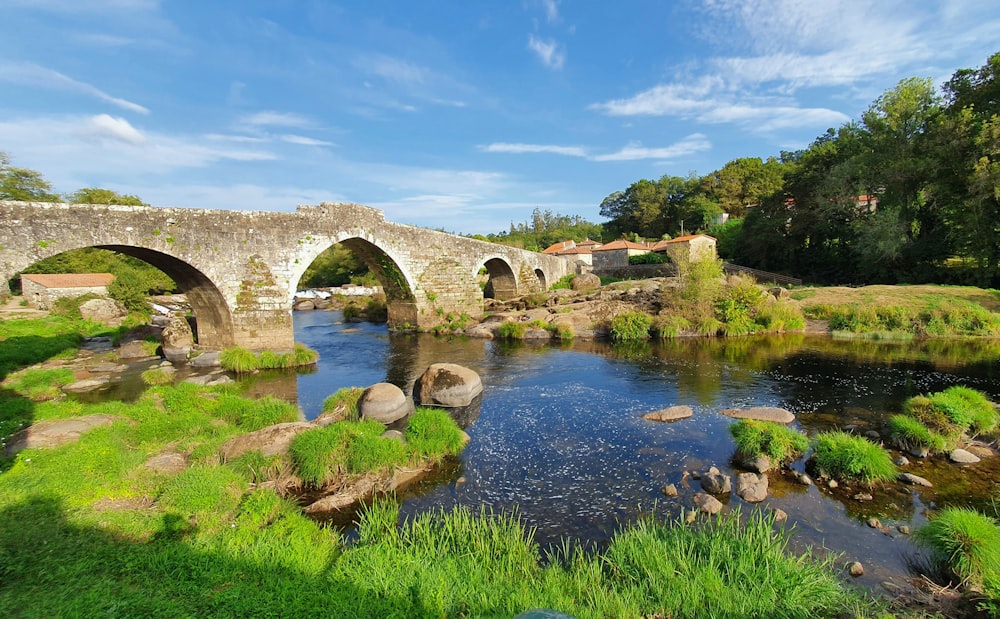 brown concrete bridge over river under blue sky during daytime