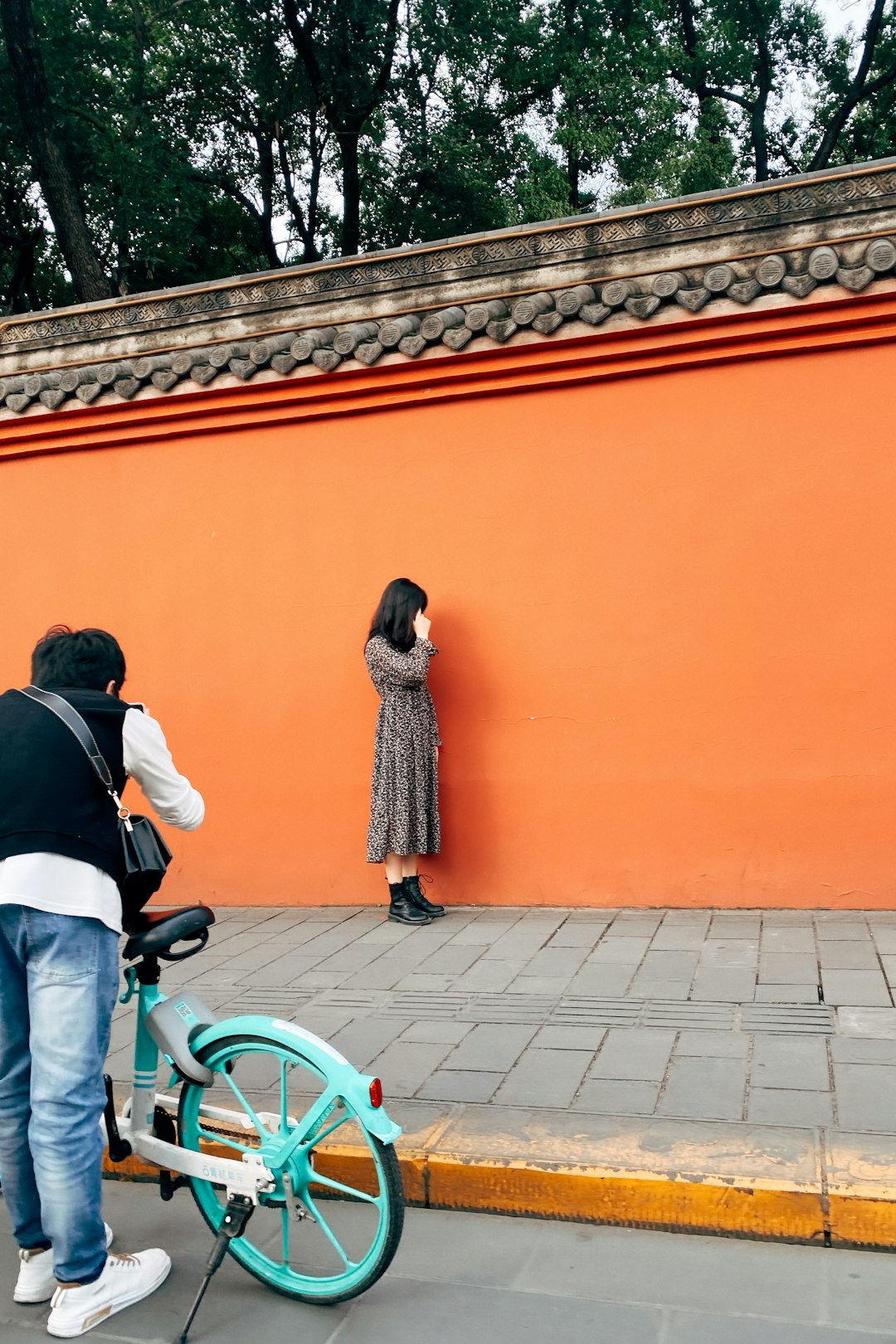 man and woman standing beside orange wall during daytime