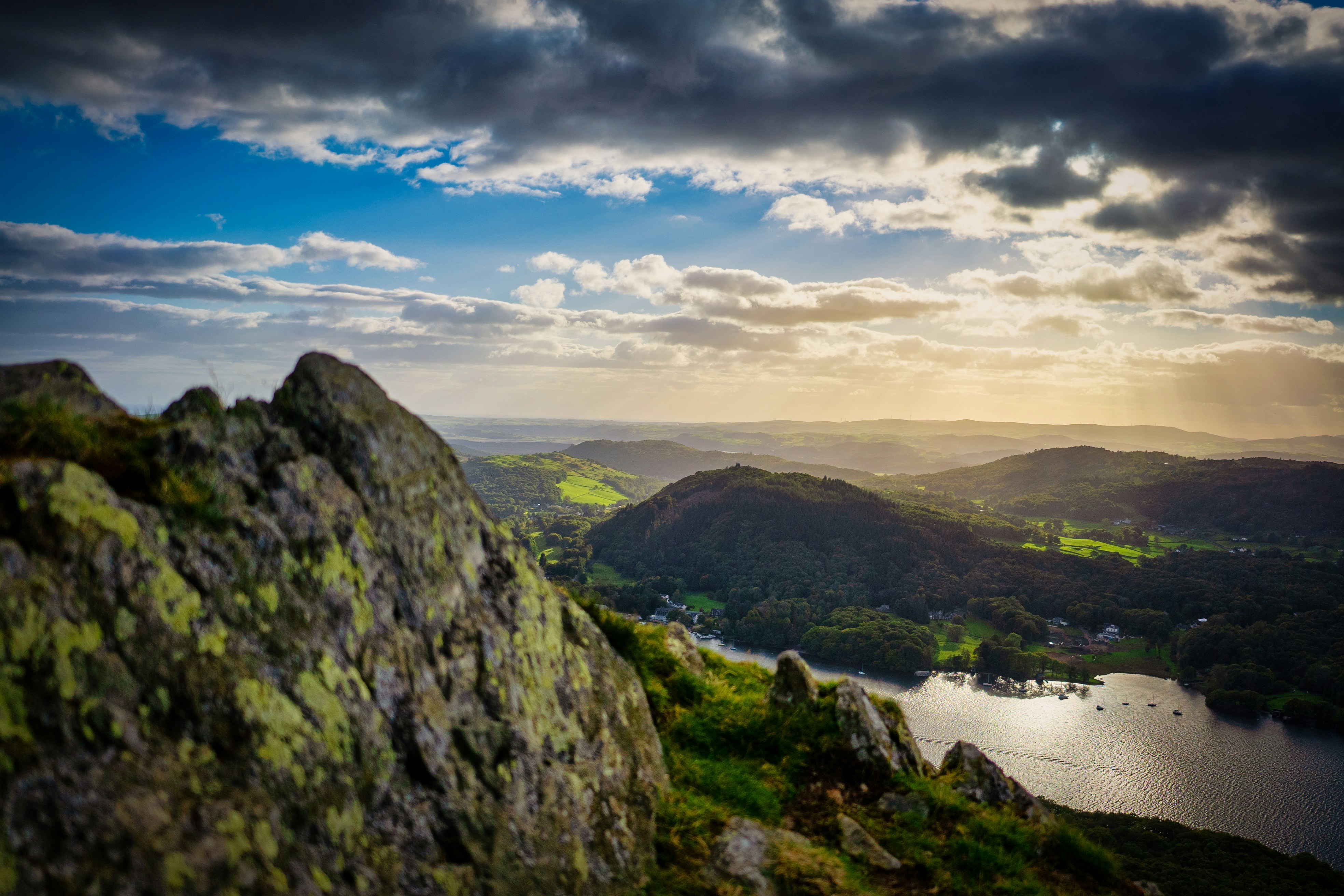 green mountains near body of water under blue sky during daytime