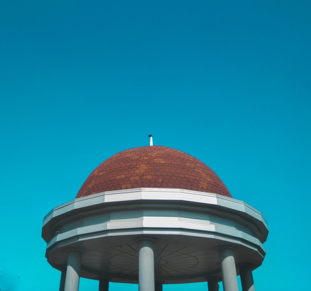 Edificio de cúpula marrón y blanco bajo el cielo azul durante el día