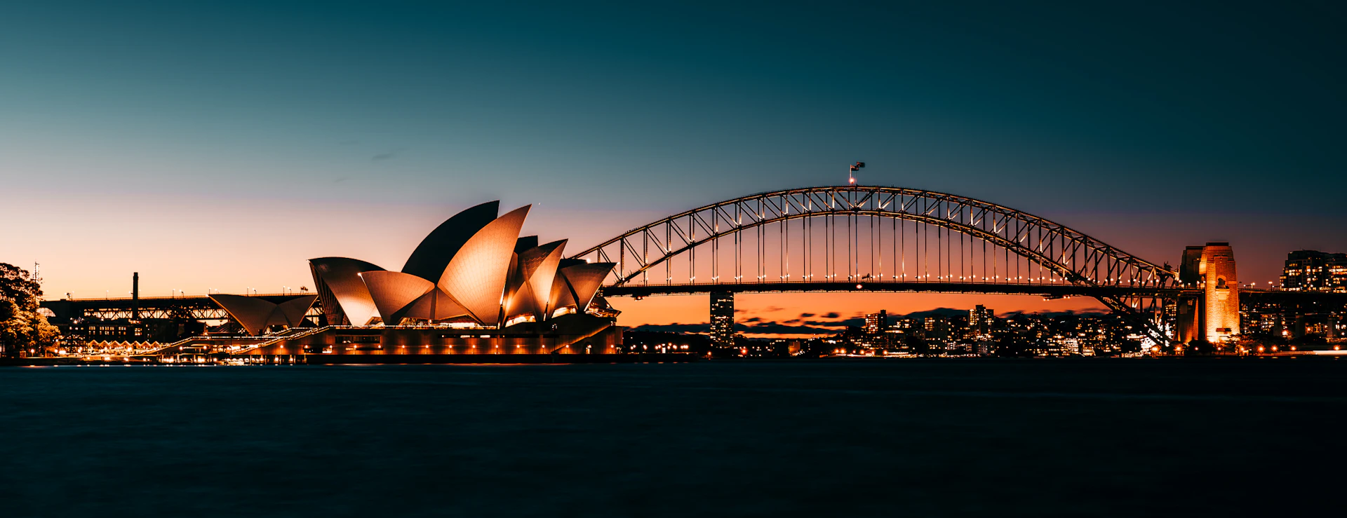 the sydney opera house is lit up at night
