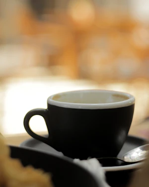 A cup of black drip coffee on a saucer