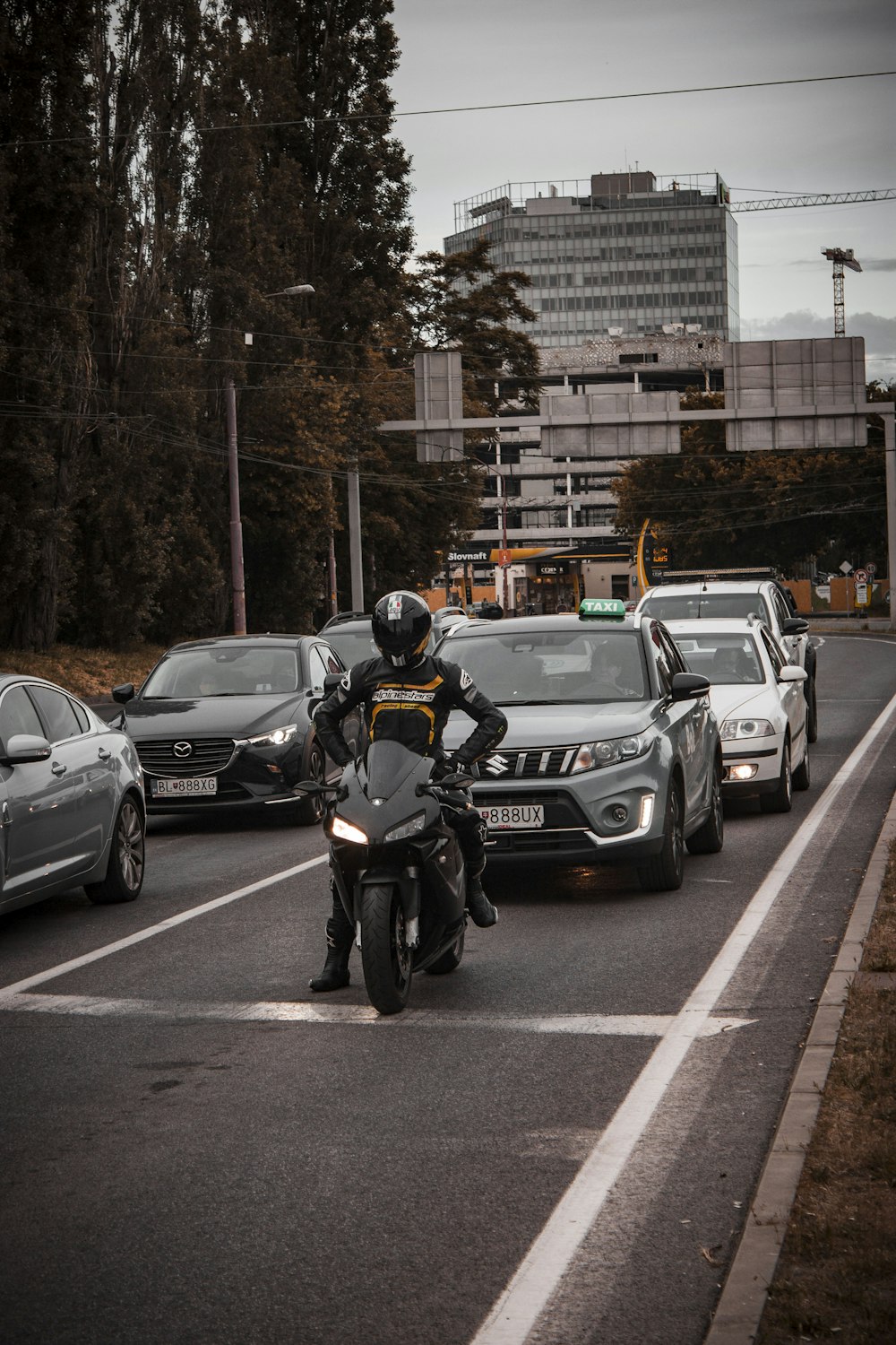 man in black helmet riding black sports bike on road during daytime