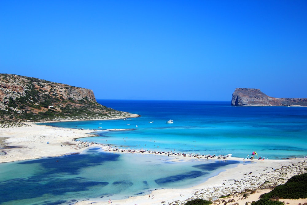 brown rock formation on blue sea under blue sky during daytime