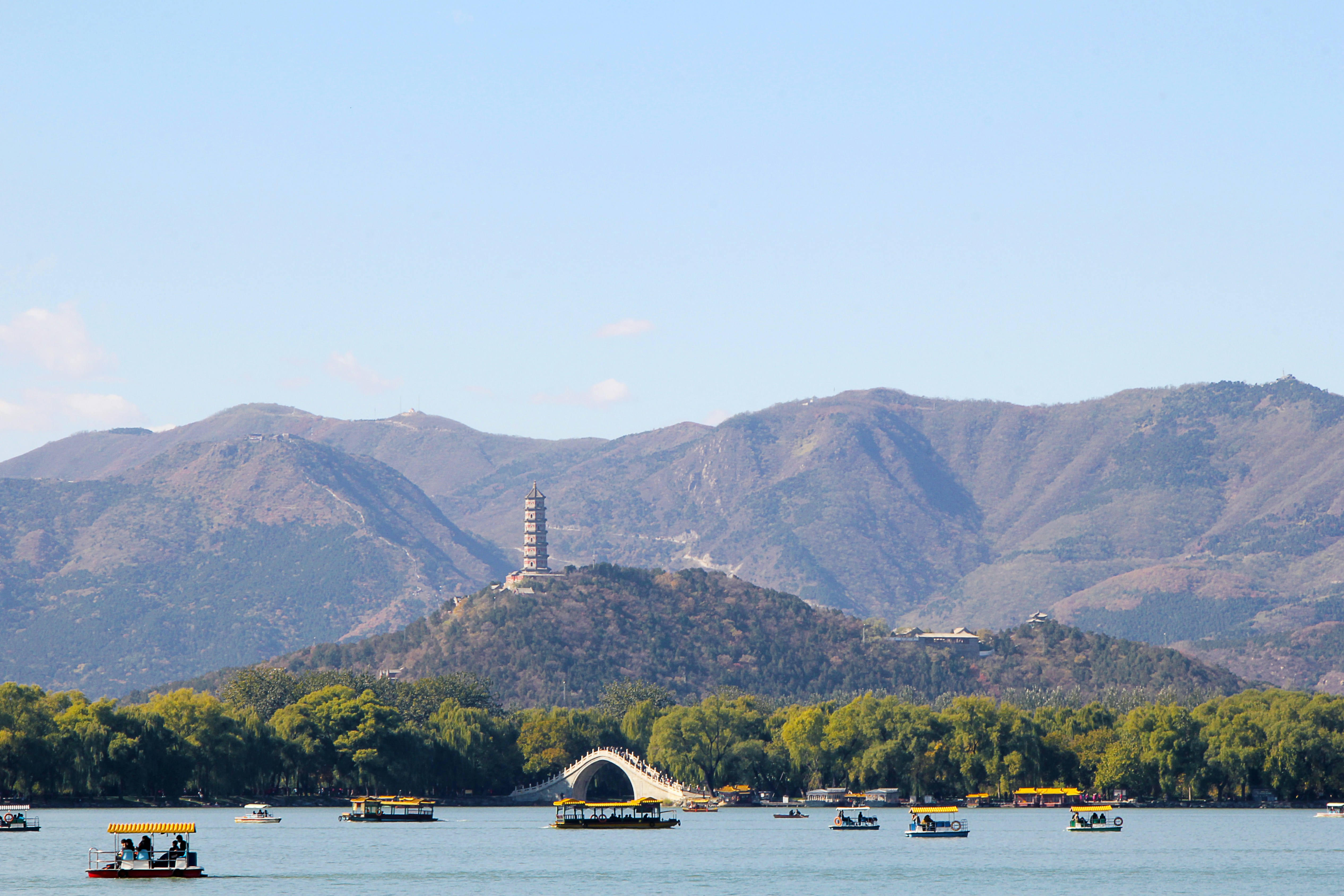 white boat on water near mountain during daytime