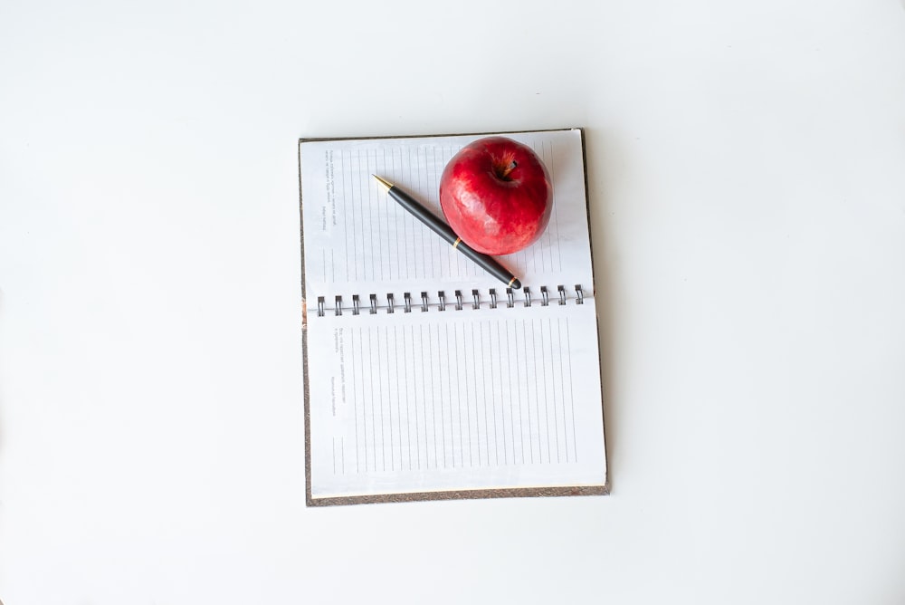 red apple on white notebook