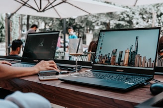 person using laptop computer on brown wooden table