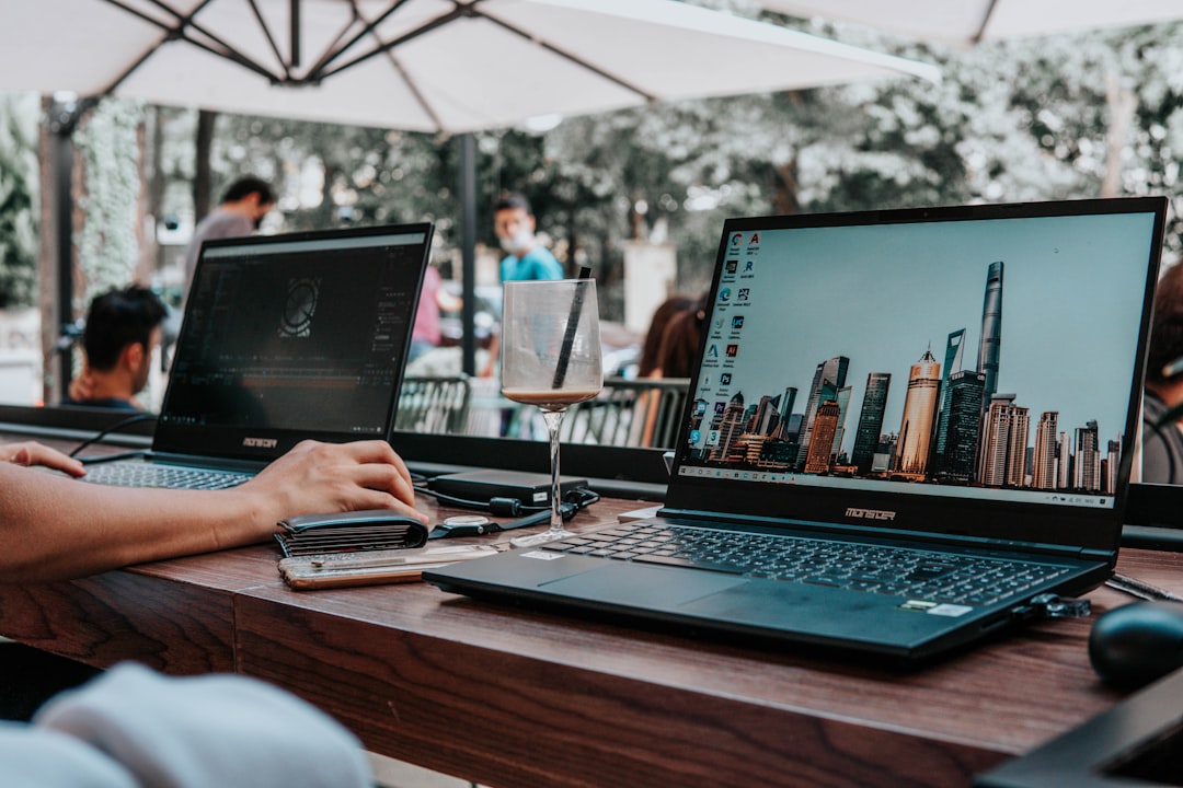 person using laptop computer on brown wooden table