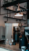 An inviting coffee corner setup featuring a modern espresso machine, ceramic mugs, and a small potted plant, bathed in natural morning light.