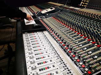 person in black long sleeve shirt standing in front of audio mixer