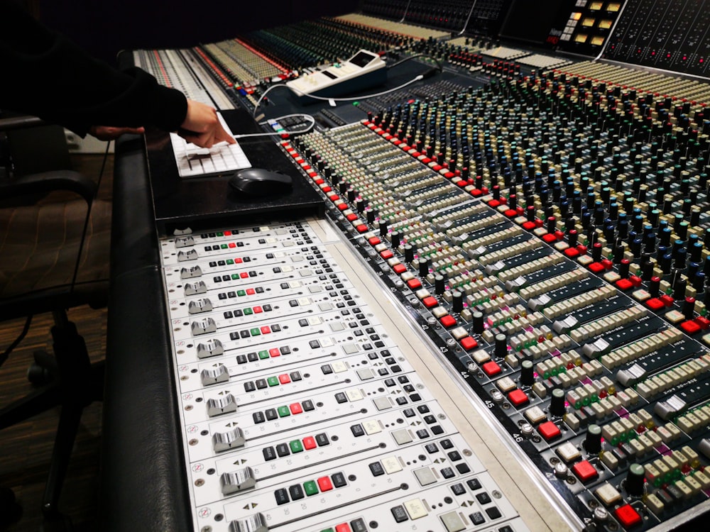 person in black long sleeve shirt standing in front of audio mixer