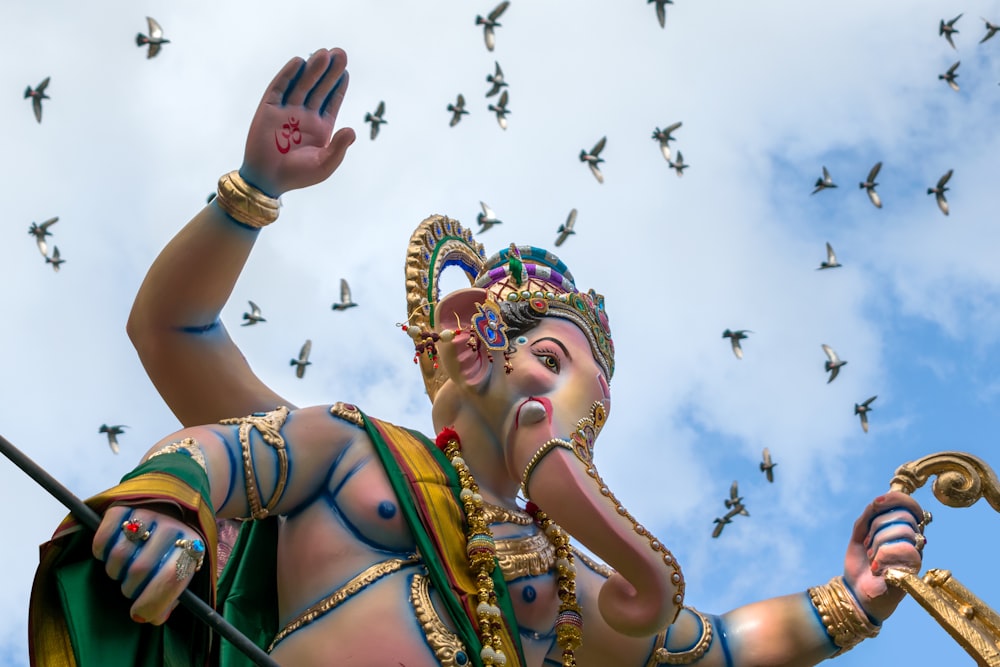 woman in gold and blue dress with gold crown under white clouds during daytime