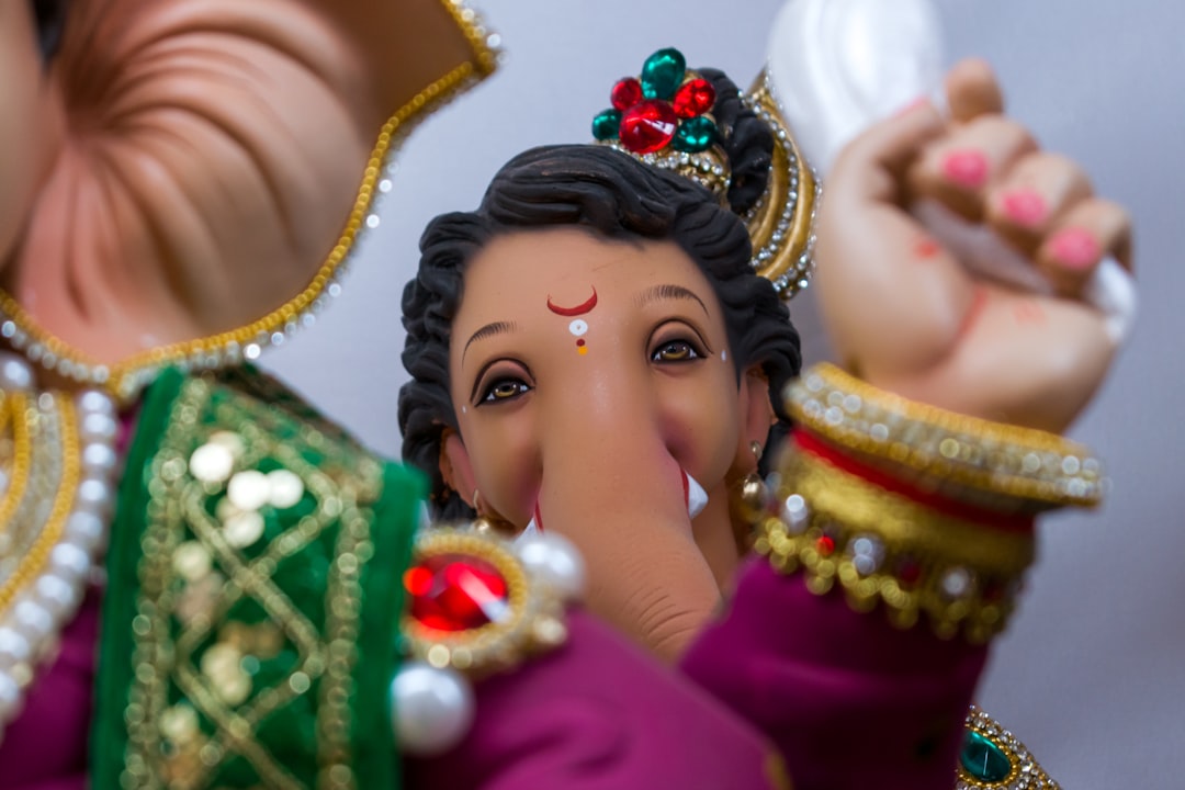 woman in red dress wearing gold crown, Beautiful idols of Lord Ganesha on display at a workshop in Mumbai