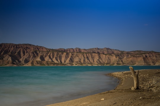 brown mountain near body of water during daytime in Negratín Reservoir Spain