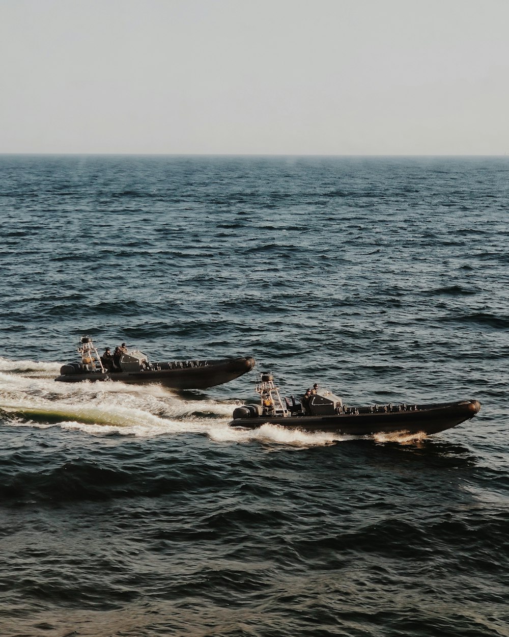 people riding on white and black boat on sea during daytime