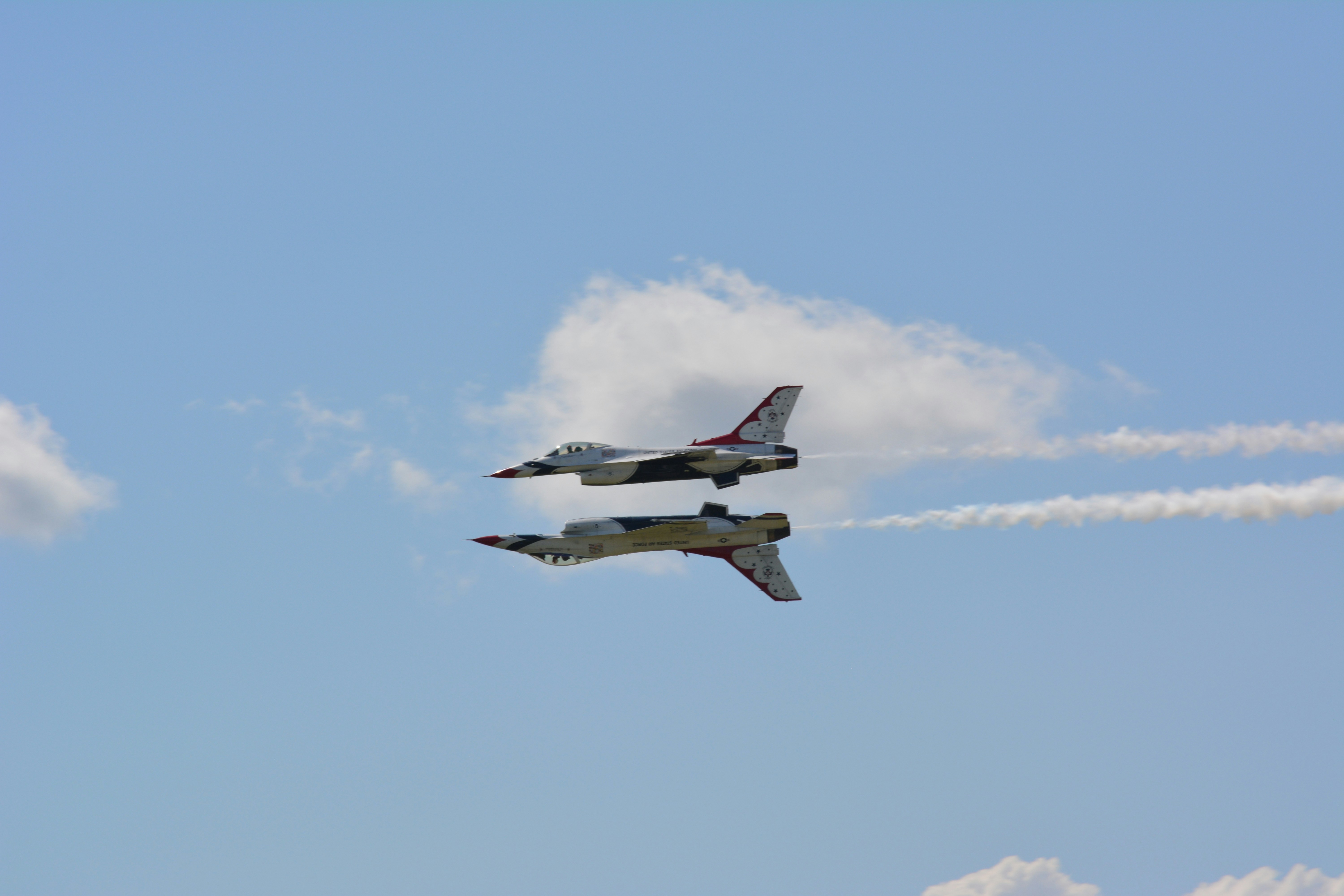 white and red jet plane in mid air during daytime