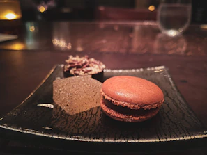 Close-up of a matte gold-accented dessert sculpture bathed in warm natural light