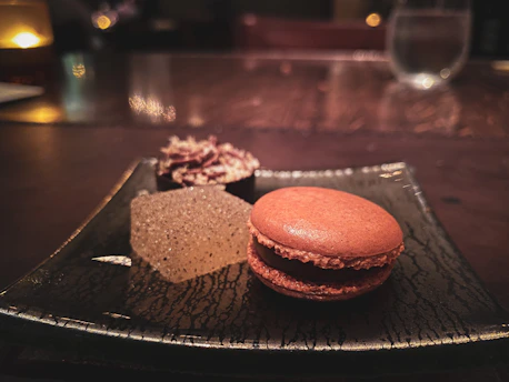 A serene close-up of a delicate Japanese-Vietnamese dessert on a minimalist white plate with beige background.