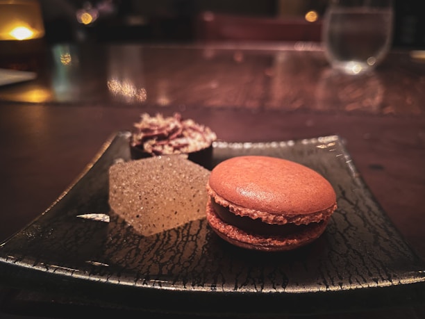 A close-up of a comforting dessert with subtle brown and cream colors, softly lit to highlight its creamy texture on a minimalist plate.