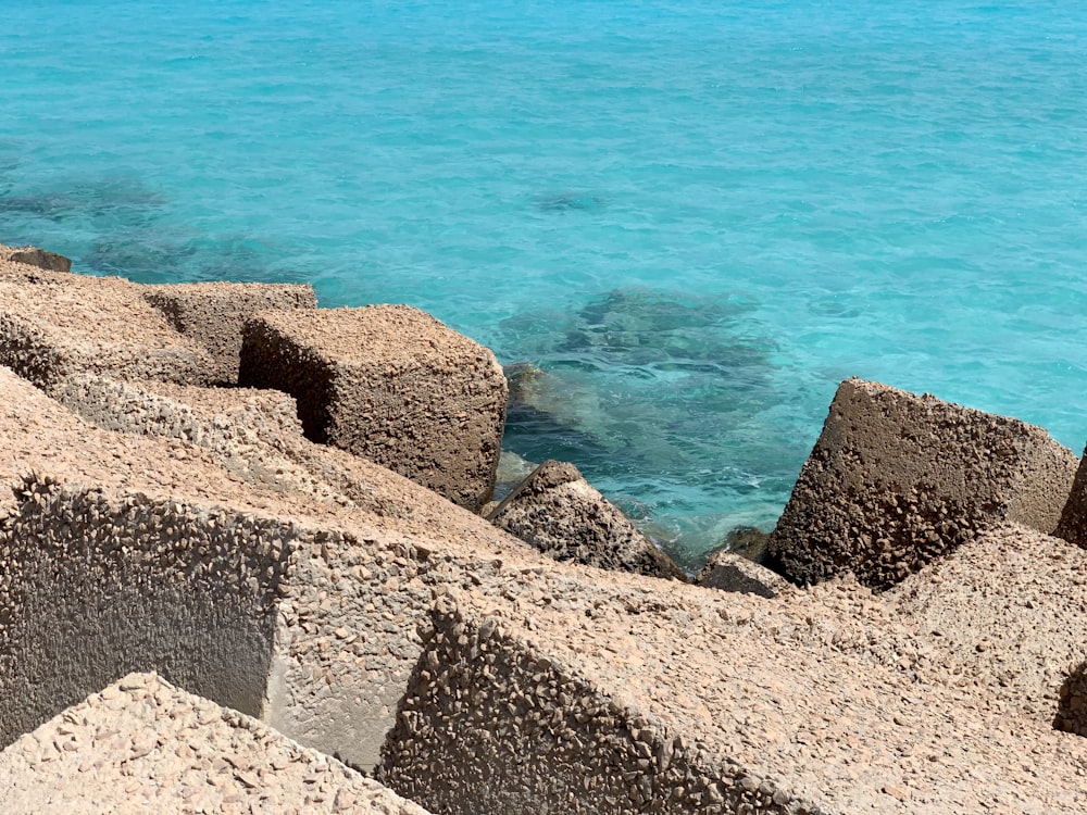 gray rocky shore near blue sea during daytime