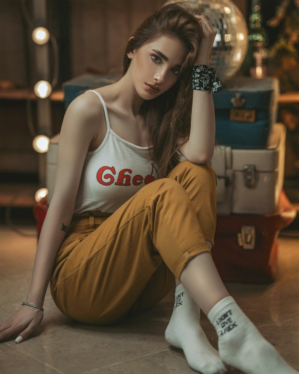 woman in white tank top and brown pants sitting on brown wooden chair