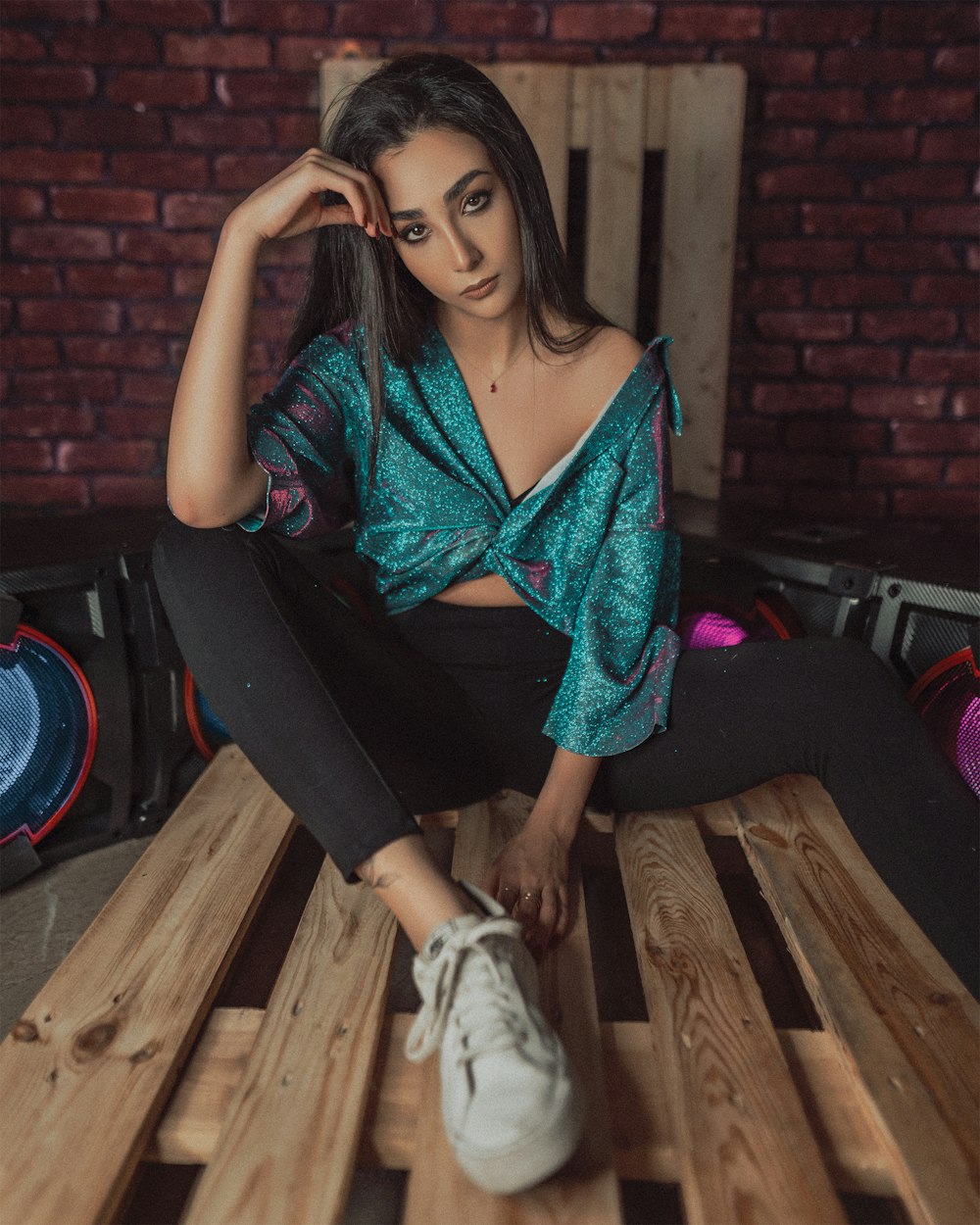 woman in green and black dress sitting on brown wooden bench