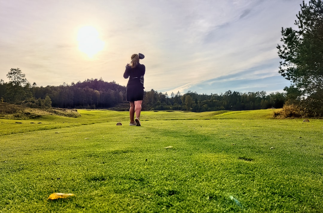 Lady golfer teeing off on a beautiful day 