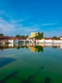 white and brown concrete building near body of water under blue sky during daytime