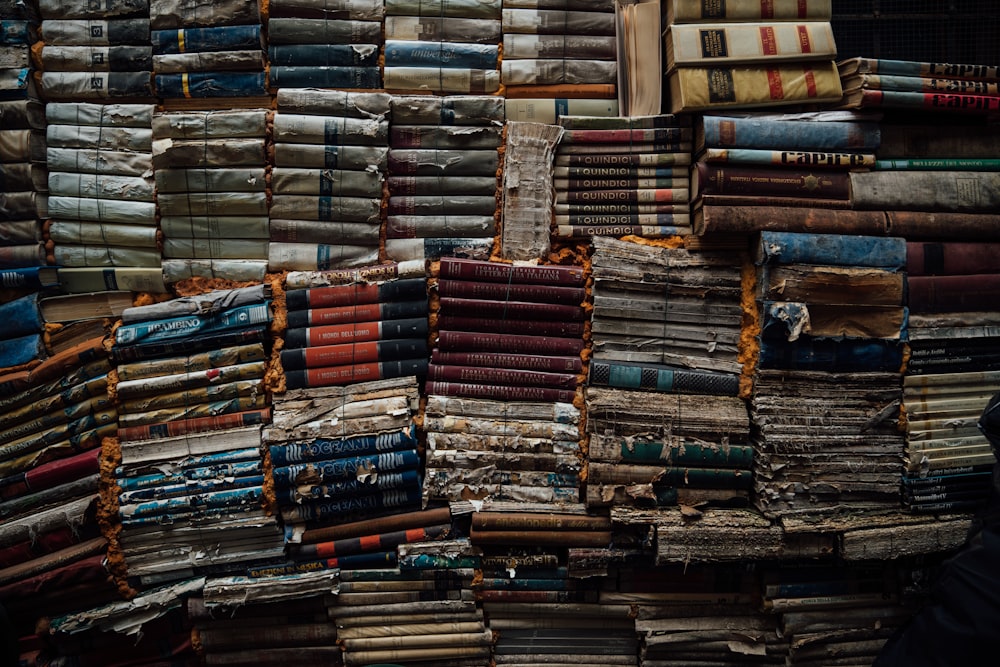 stack of books on brown wooden shelf