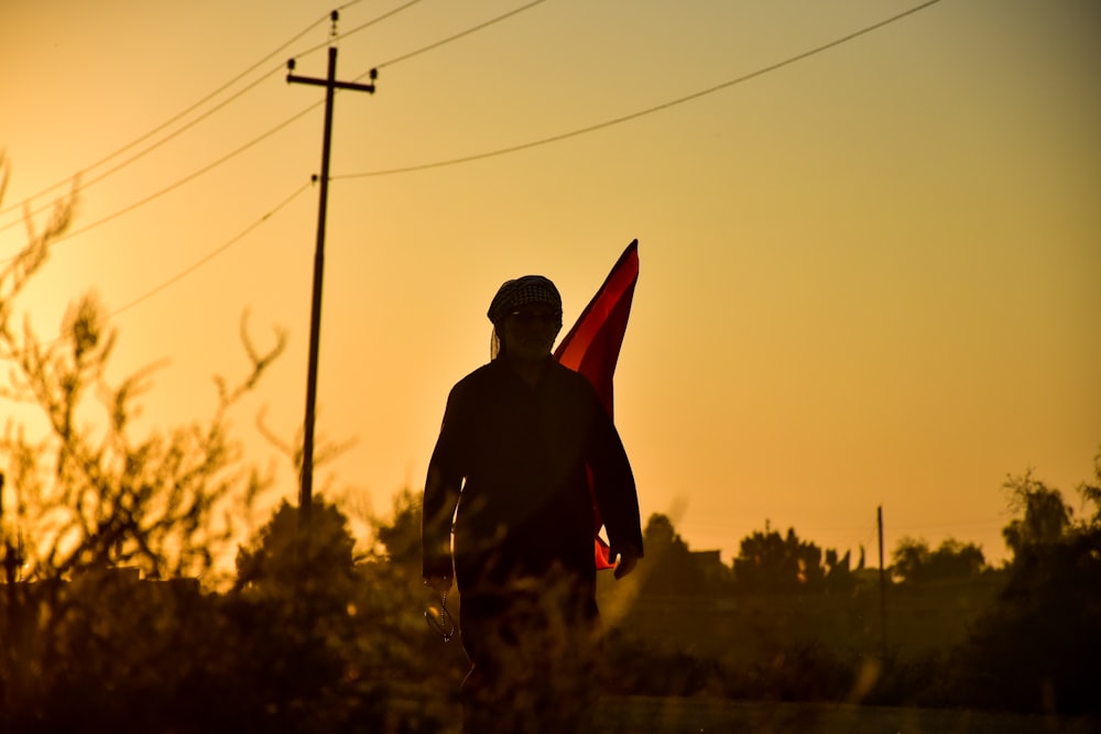 man in black jacket holding red flag