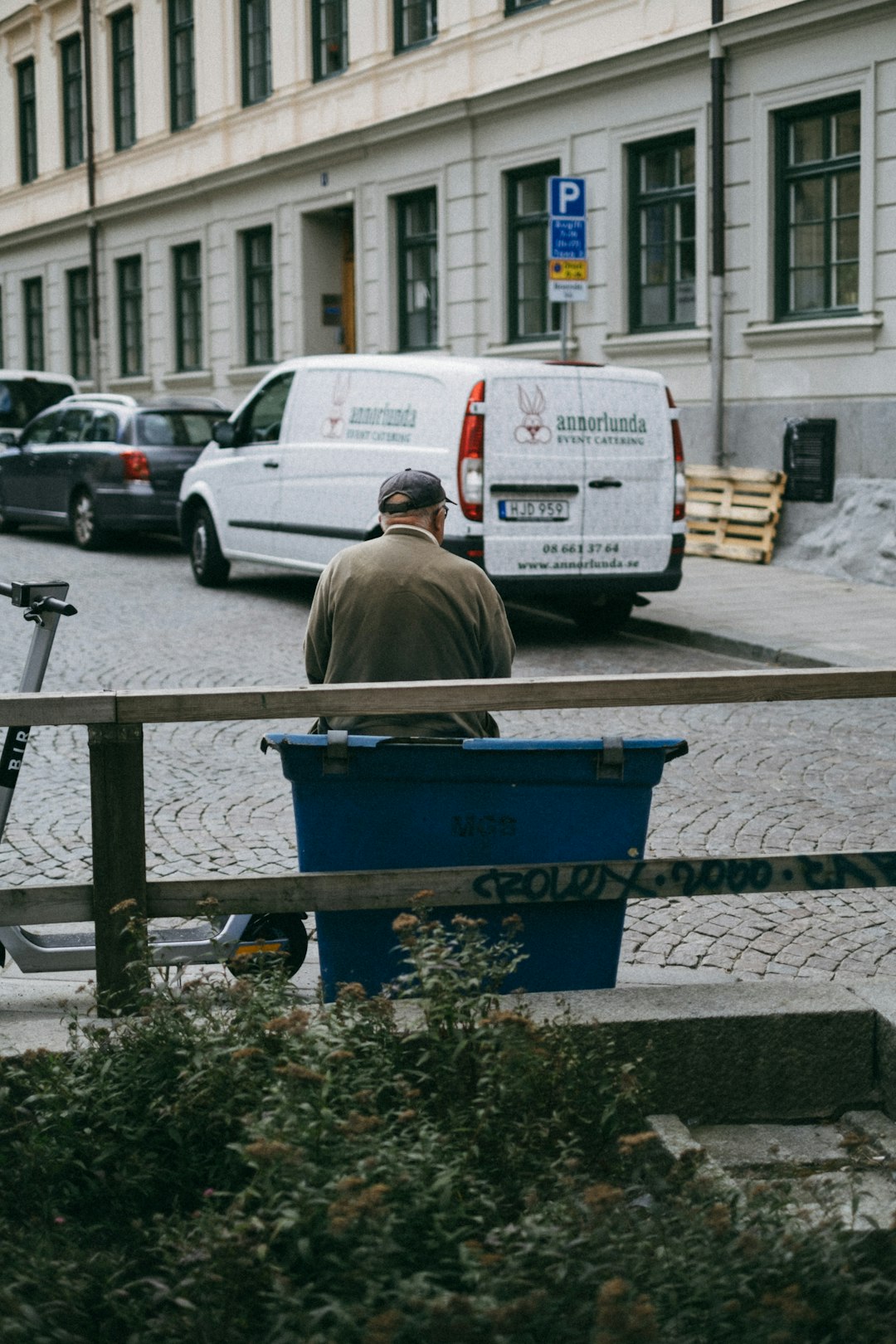 man in brown jacket sitting on black steel bench during daytime