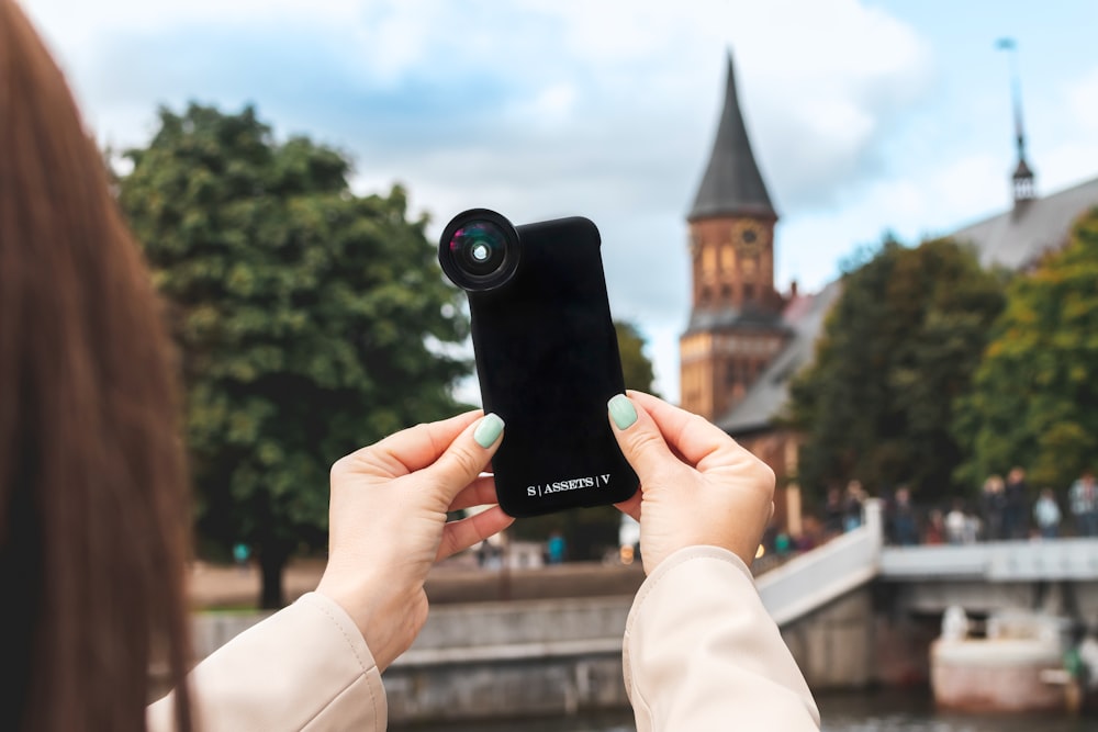 person holding black camera taking photo of brown concrete building during daytime