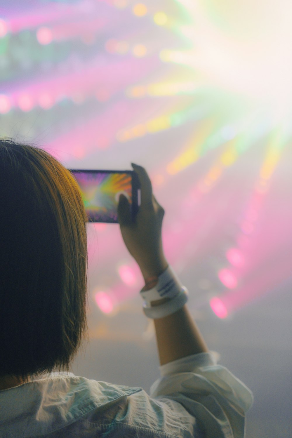 woman in white long sleeve shirt holding black smartphone