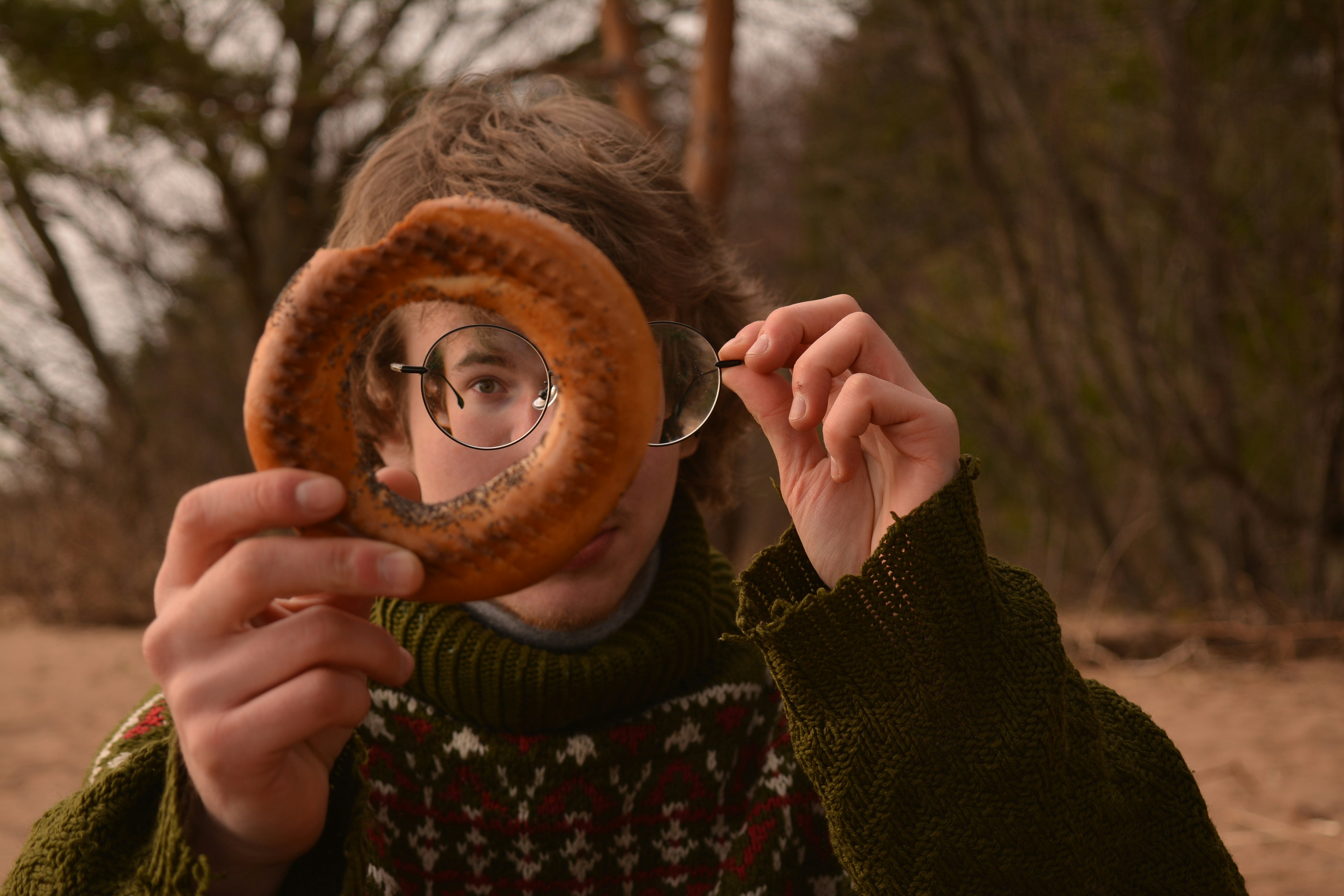 woman in brown knit cap holding brown wooden round mirror