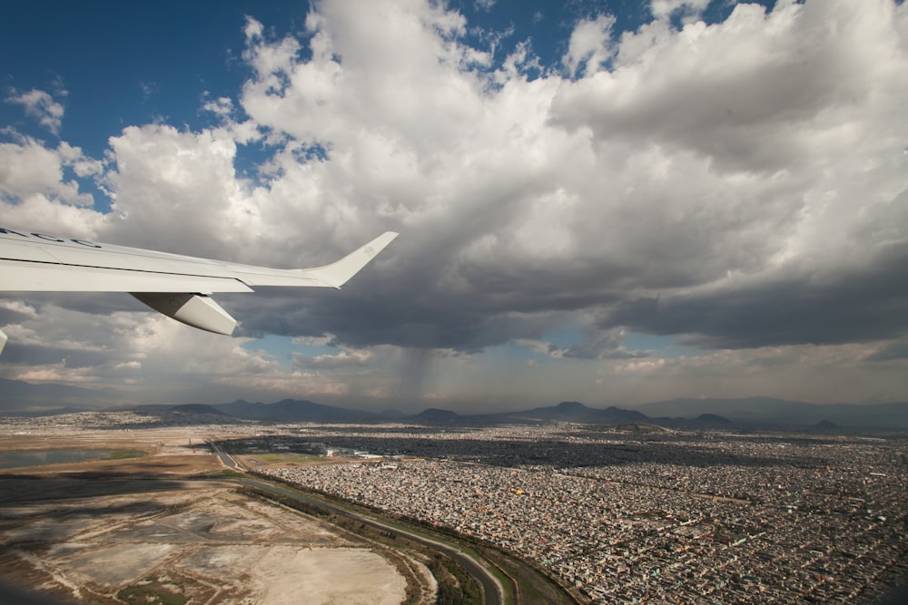 white airplane wing over the clouds during daytime