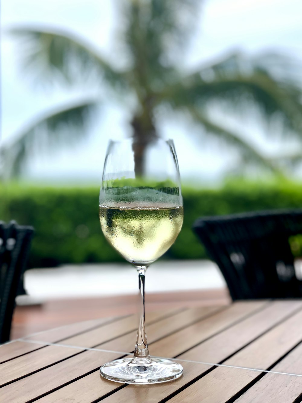 clear wine glass with yellow liquid on brown wooden table